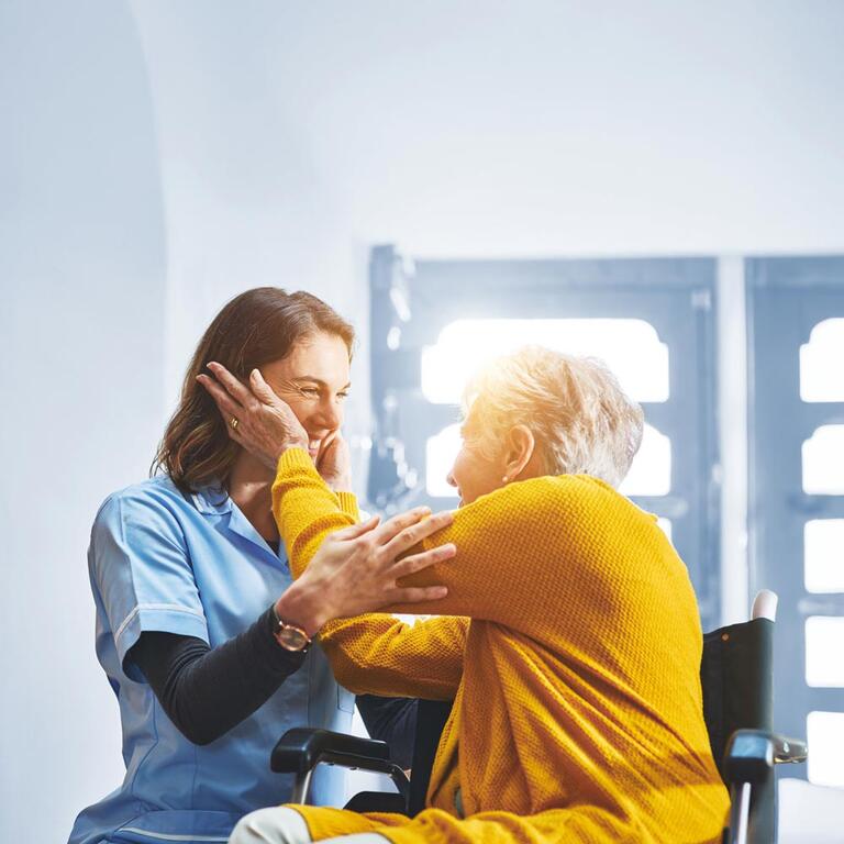 A patient embracing a caregiver