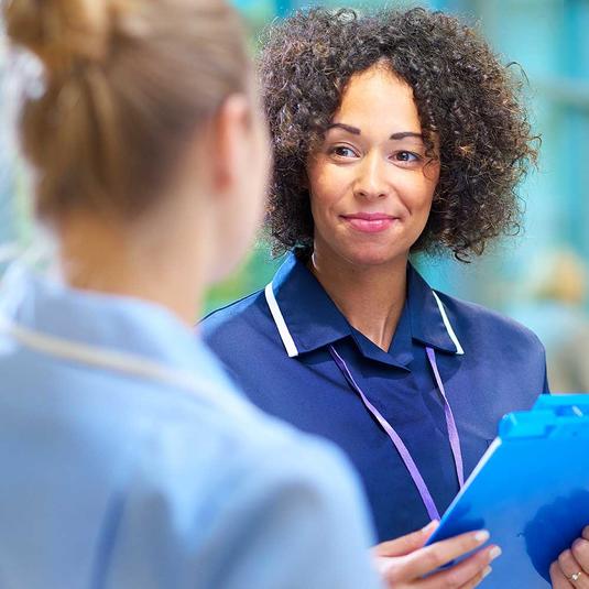 A nurse graduate listening to another nurse A nurse graduate listening to another nurse