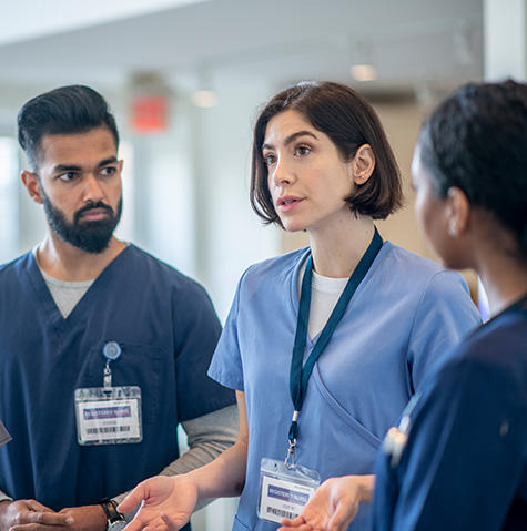 A nurse speaking with other nurses A nurse speaking with other nurses