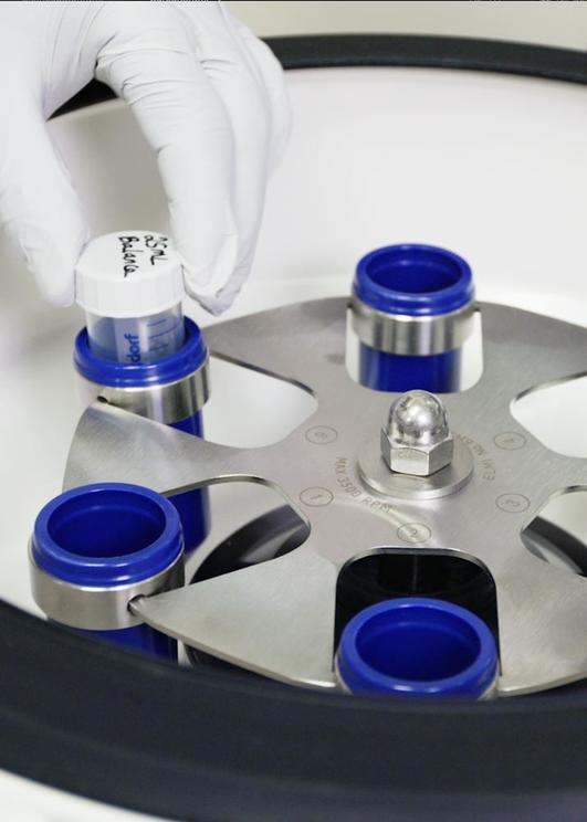 hand holding a test tube in a lab device
