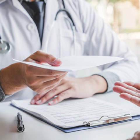 A Doctor giving a patient some paper forms