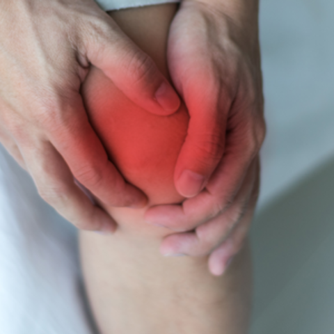 A person holding their sore knee
